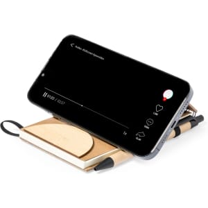 A wooden notebook holder in tan with a smartphone resting on it, featuring a small notebook and a pen.