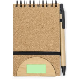 A cork notebook with a black pen, featuring a bamboo section and an elastic band for closure.
