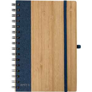 A spiral-bound notebook featuring a bamboo cover with a dark blue fabric side and an elastic band.