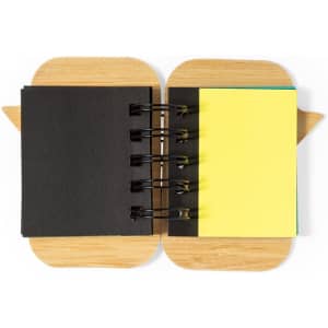 A sticky notepad featuring a wooden cover, with black and yellow sticky notes visible inside.