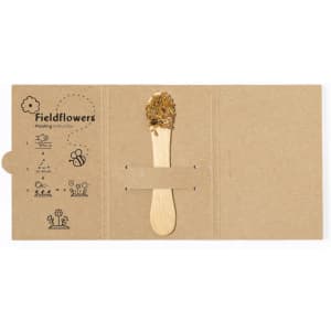 A cardboard package containing a seed stick with a wooden stick topped with various seeds for planting.