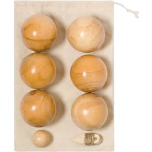 Wooden petanque balls on a cream fabric background, including six large balls and one smaller ball, with a storage pouch.