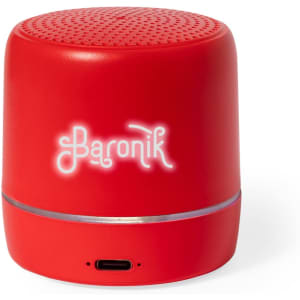 A red speaker with a circular shape, featuring a raised logo and a charging port on the side.