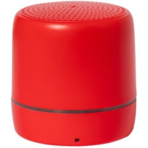 A red portable speaker with a round shape and a textured surface, featuring a logo on its side.