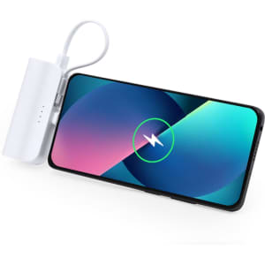 A white power bank is connected to a smartphone, displaying a charging graphic on the screen.