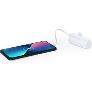 A white power bank connected to a smartphone, with a vibrant screen displaying colourful graphics.