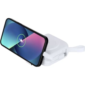 A white multifunction travel adapter with a phone resting on top, showcasing wireless charging capability.