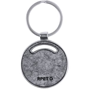 A round grey keyring with a metal ring, featuring a logo on one side. The material has a textured finish.