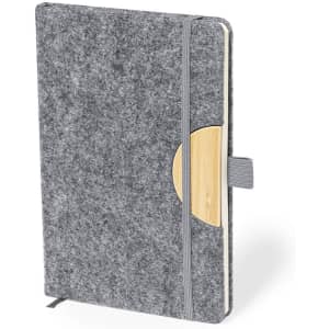 A grey notepad with a textured cover, featuring a wooden accent and an elastic band closure.