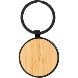 A round keyring with a black metal frame and a wooden, bamboo-like centre. It has a simple design and a branding logo.