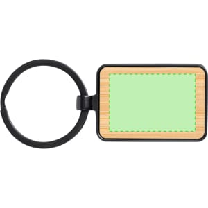 A rectangular keyring with a black metal ring and a green rectangle in the centre, featuring a wood-like background.