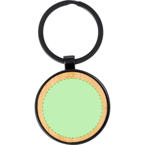 A round keyring featuring a black metal loop and a light green circular wooden section with a textured surface.