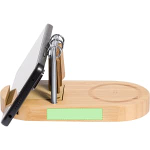 A bamboo multifunction charger featuring a wireless charging pad, phone stand, and pen holder. It includes a logo.