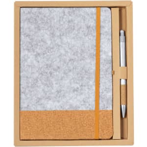 A grey notebook with a cork bottom, elastic band, and a matching pen in a cardboard box.