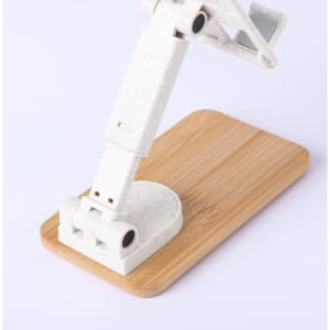 A white phone stand made of eco-friendly material, featuring an adjustable arm on a wooden base.