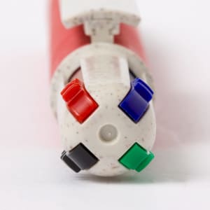 A red pen with four interchangeable tips in black, green, blue, and red. It features a logo on the side.