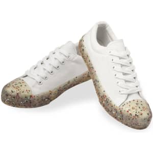 A pair of white trainers with a speckled, translucent sole. The shoes feature laces and a rounded toe design.