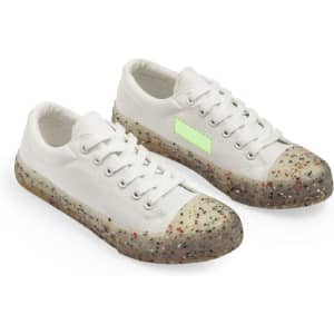 White trainers with a speckled, translucent sole feature a textured toe cap. The shoes have a logo on the side.