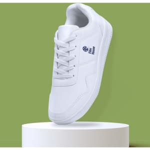 A white sneaker with a logo, displayed on a round pedestal against a green background.
