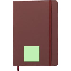 A brown notepad with a green square patch and a red elastic band closure. Features a ribbon bookmark and a logo.