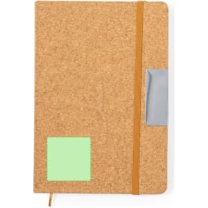 A cork notebook with a green sticky note area, orange elastic band, and a grey pocket on the front.