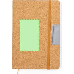 A cork notebook with a green insert and an orange elastic band, featuring a silver clip on the side.