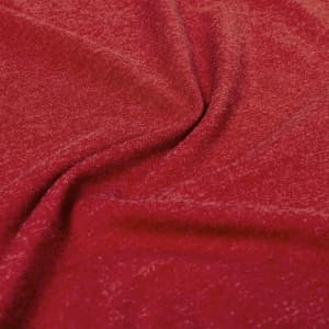 A close-up of a red fabric with a textured pattern, showcasing the softness and draping quality of the material.