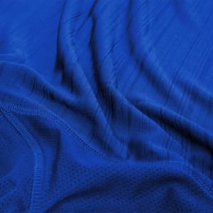 A blue adult T-shirt with a textured fabric design, featuring a logo on one section.