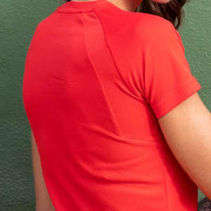 A red children's T-shirt featuring a textured design and a logo on the back.