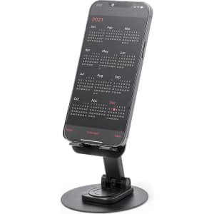 A black phone stand displaying a smartphone with a calendar on its screen. The stand has a circular base.