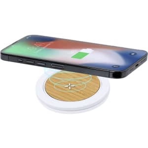 A wireless charger with a sleek white base and a bamboo surface, complemented by a smartphone displaying a charging icon.