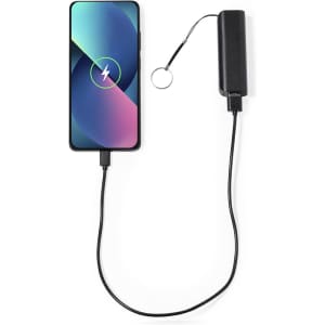 A black power bank connected to a smartphone, featuring a charging indicator on the phone's screen.
