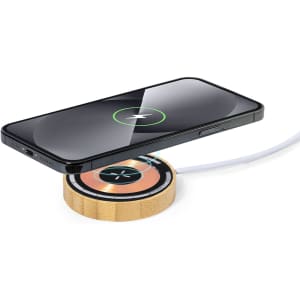 A wireless charger in a circular bamboo design, with a smartphone placed on top, showcasing a charging indicator.