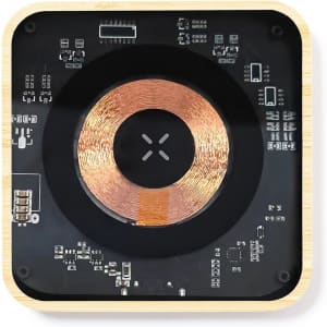 A wireless charger with a wooden frame, featuring a circular coil design and intricate circuit details.