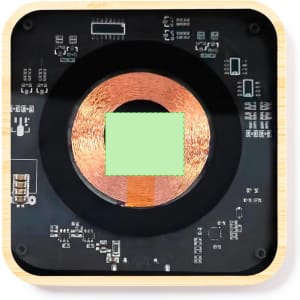 A square wireless charger with a copper coil at the centre, surrounded by circuit board components. It features a wooden base.
