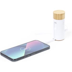 A power bank with a bamboo top and white body, connected to a smartphone with a charging cable.