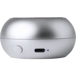 A silver portable speaker with a smooth round shape, featuring a power button and a USB-C port.