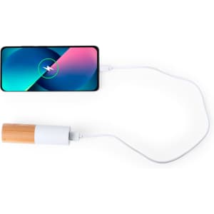 A power bank in a wooden and white design connected to a smartphone via a charging cable.