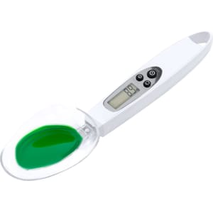 A white digital weighing scale with a transparent bowl containing green liquid. The scale features buttons and a display.