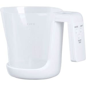 A white measuring scale with a clear cup and a handle, featuring buttons for unit selection and an on/off function.