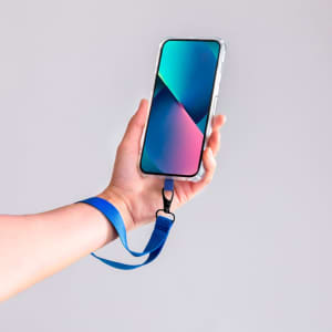 A hand holds a smartphone with a blue strap attached, displaying a vibrant screen in shades of green and pink.