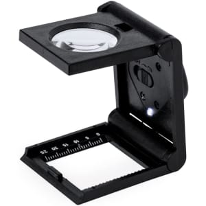 A black 8X magnifier with a built-in light and measurement scale, designed for detailed viewing.