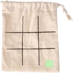 A cream drawstring bag featuring a simple grid design in brown, with a small green square in one corner.