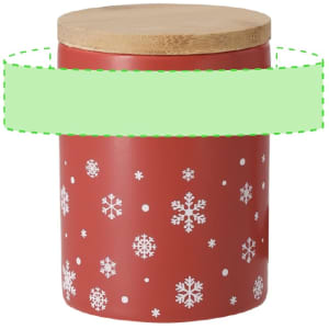 A red ceramic mug with a wooden lid, featuring white snowflake patterns. It has a branding logo on it.