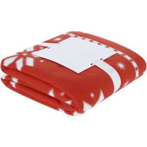 A folded red blanket featuring white snowflake patterns, neatly secured with a plain white band.