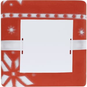A red fleece blanket featuring a white pattern and a section covered by a white label. It has branding visible.