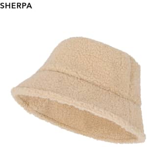 A beige beanie made from soft sherpa material, featuring a classic bucket style and a simple logo.