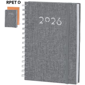 A grey spiral-bound diary with the year "2026" printed on the cover, accompanied by a smaller notebook in orange.