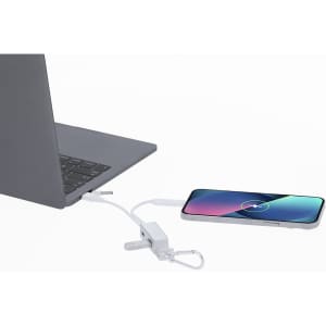 A white USB hub connects a laptop to a smartphone, showcasing sleek design and functionality.