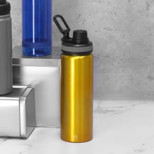 A drink bottle in a shiny gold finish, featuring a black lid and a handle, alongside other bottles.